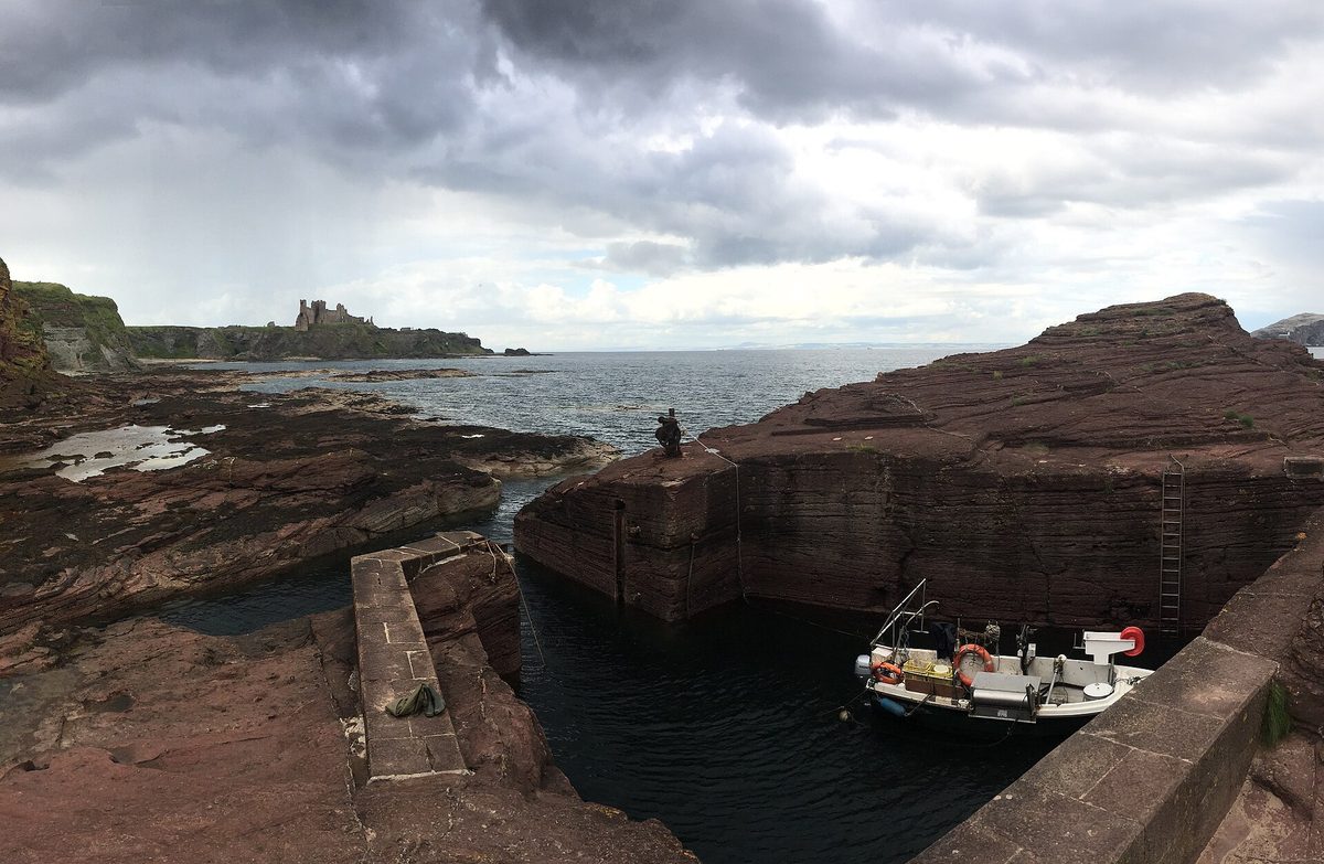 Seacliff beach in East Lothian, with Britain's smallest harbour cut into the rock and Tantallon Castle on the headland beyond