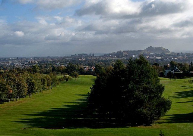 Arthur's Seat rising over the Edinburgh skyline seen across parkland