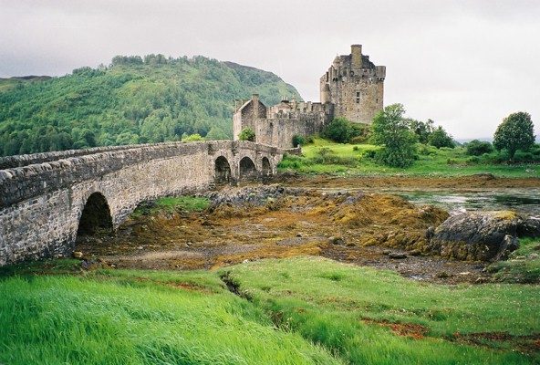 Eilean Donan Castle at low tide with weed and mud exposed beneath the stone bridge