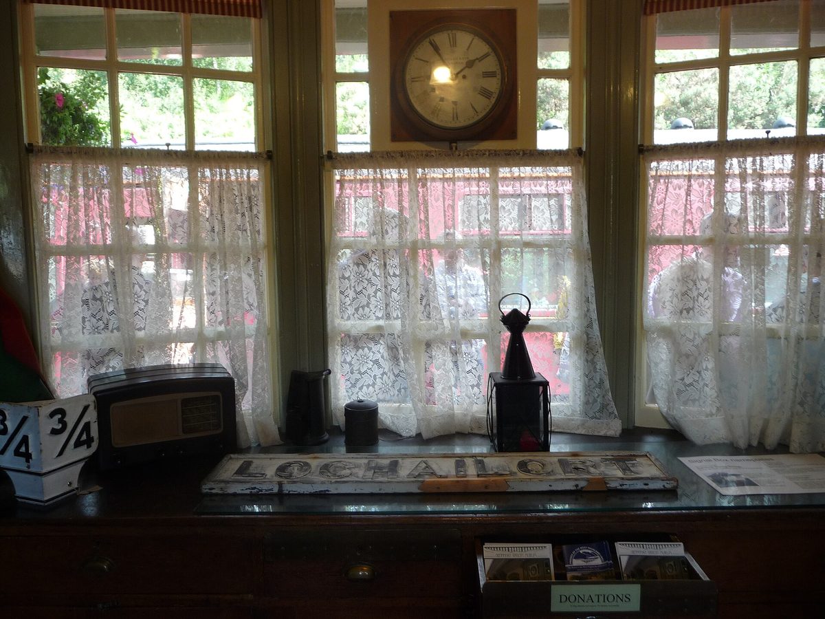 Inside the museum at Glenfinnan railway station, with maroon carriages outside the window