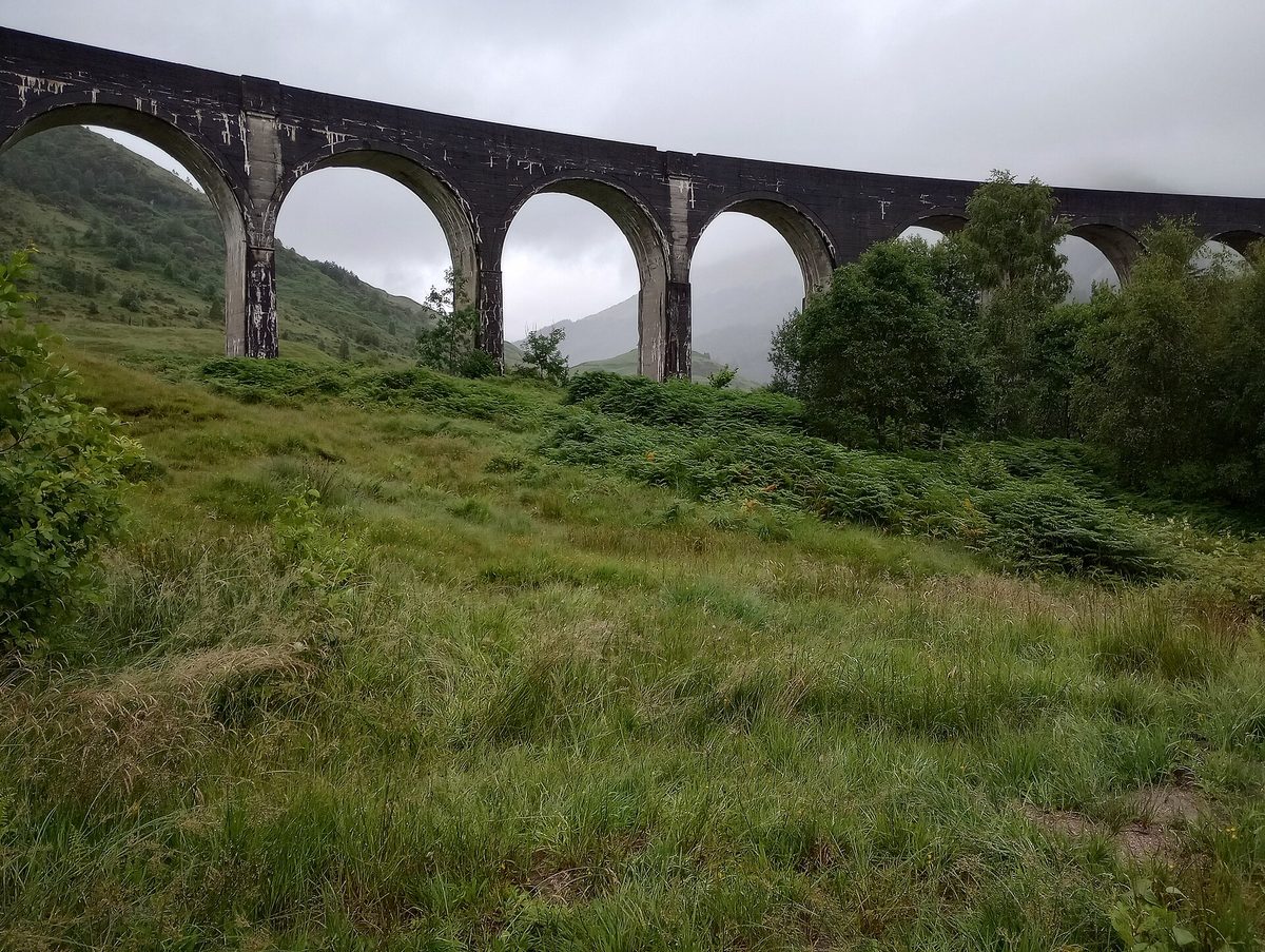 The mass-concrete arches of the Glenfinnan Viaduct seen from the glen below