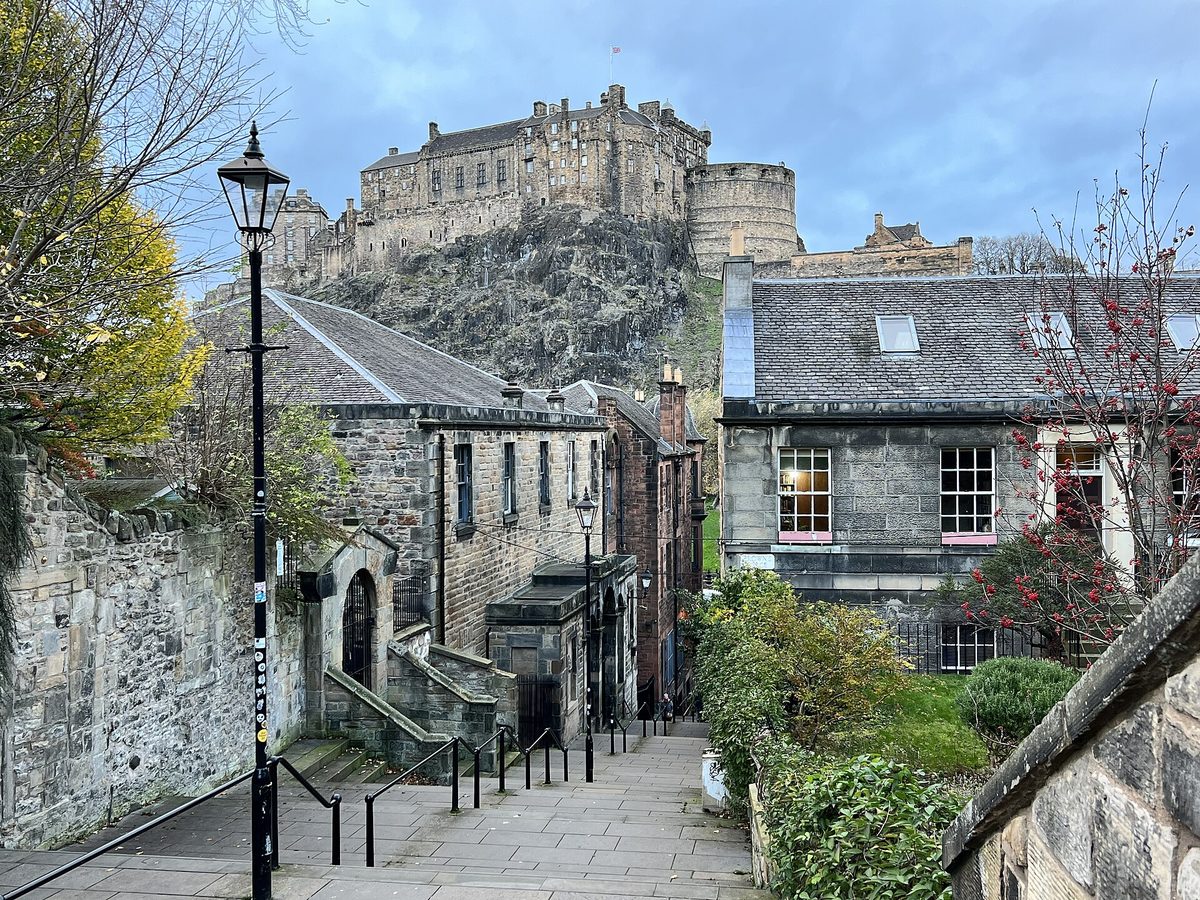 Edinburgh Castle framed between tenements from the Vennel steps, the best free castle view in the Old Town
