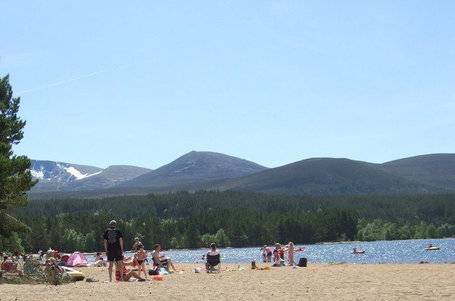 The sandy beach on Loch Morlich in Glenmore Forest Park, with the Cairngorm plateau behind