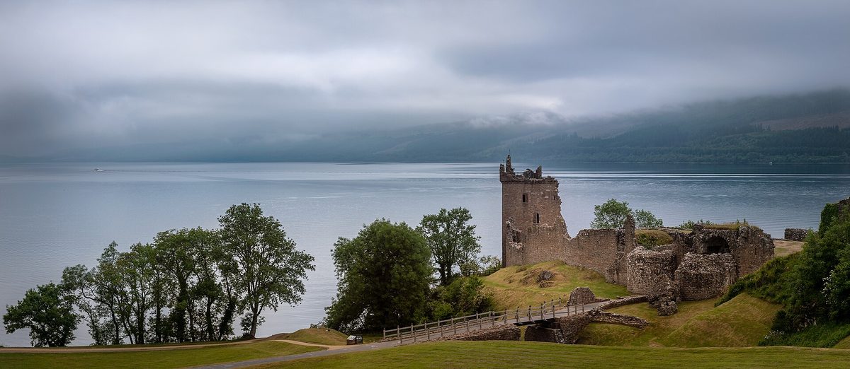 Urquhart Castle on the long, wooded bank of Loch Ness in the Great Glen