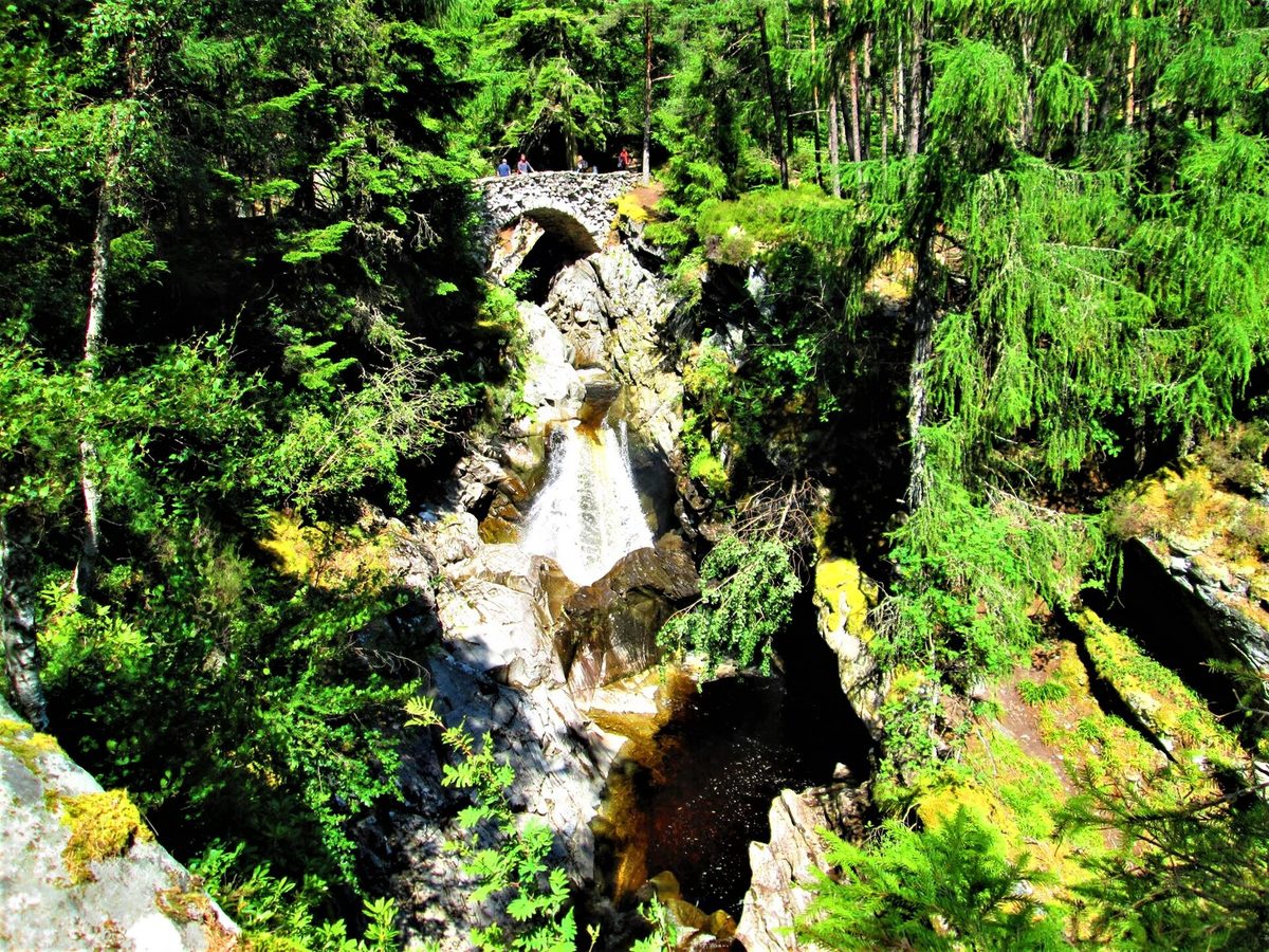 Walkers on the stone bridge above the Falls of Bruar north of Pitlochry