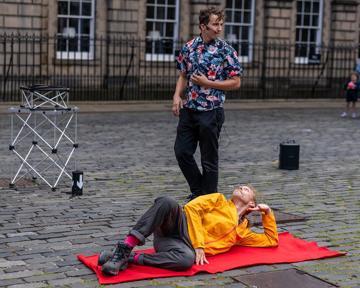 A street performer entertaining a crowd during the Edinburgh Fringe