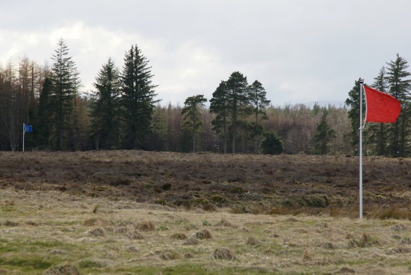 A red government flag and a blue Jacobite flag on Culloden Moor, marking how close the two lines stood