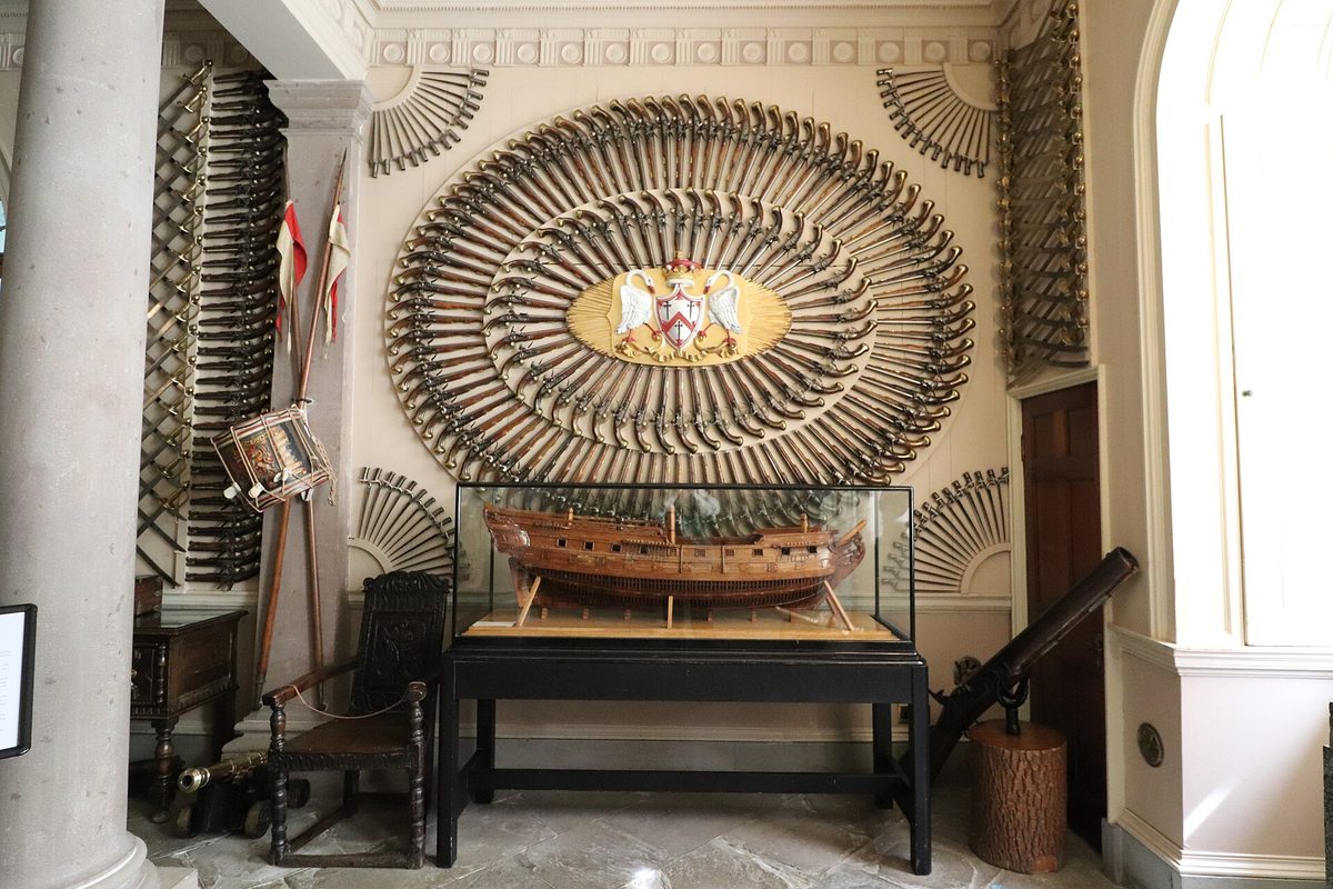 Flintlock pistols and swords fanned across the armoury wall inside Culzean Castle