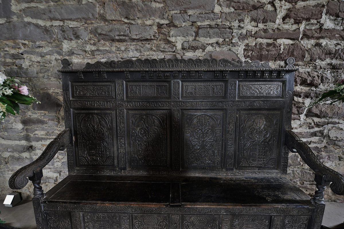 The carved oak settle in the great hall at Doune Castle