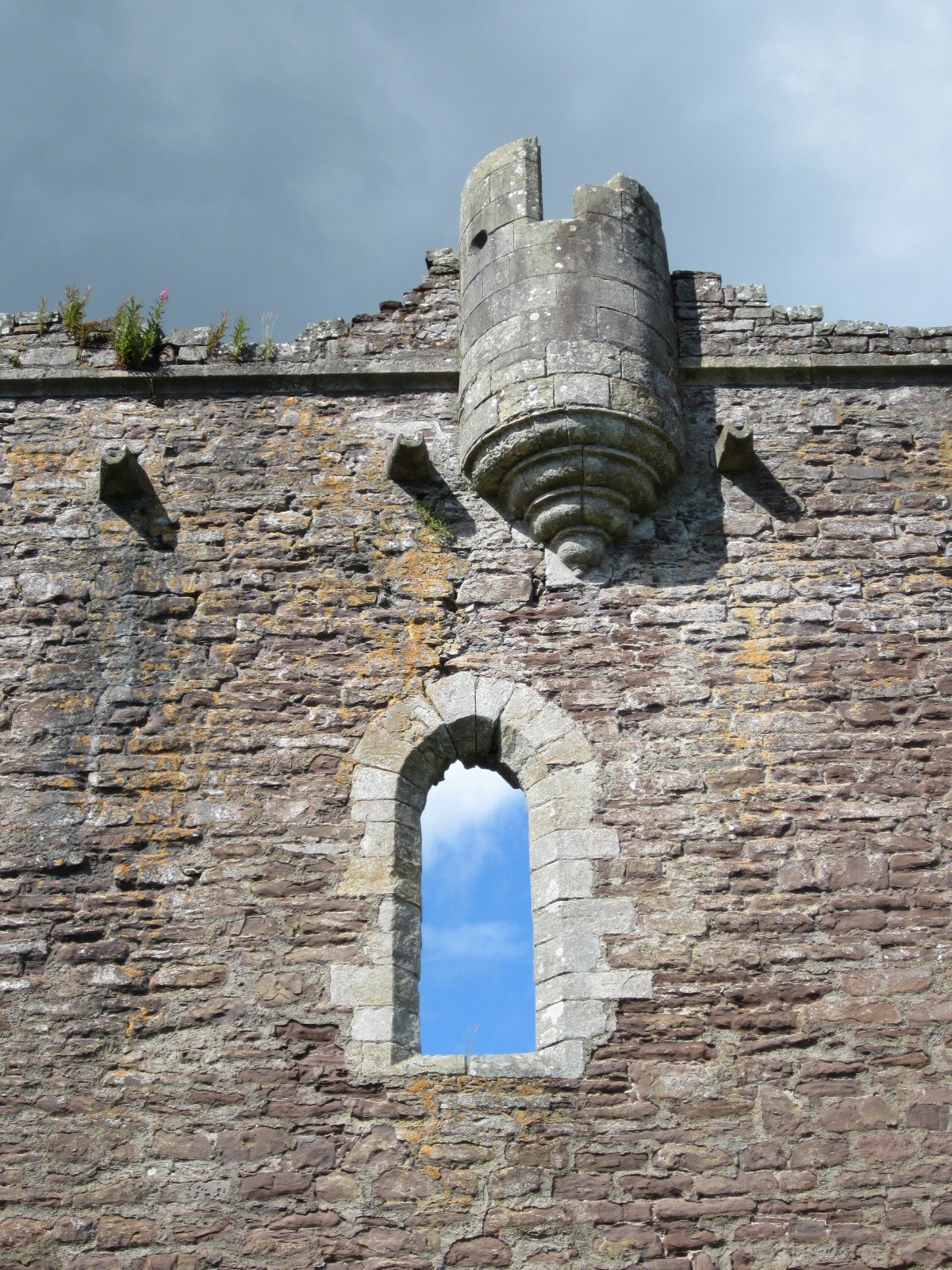 An unglazed window and corner bartizan high in the curtain wall at Doune Castle