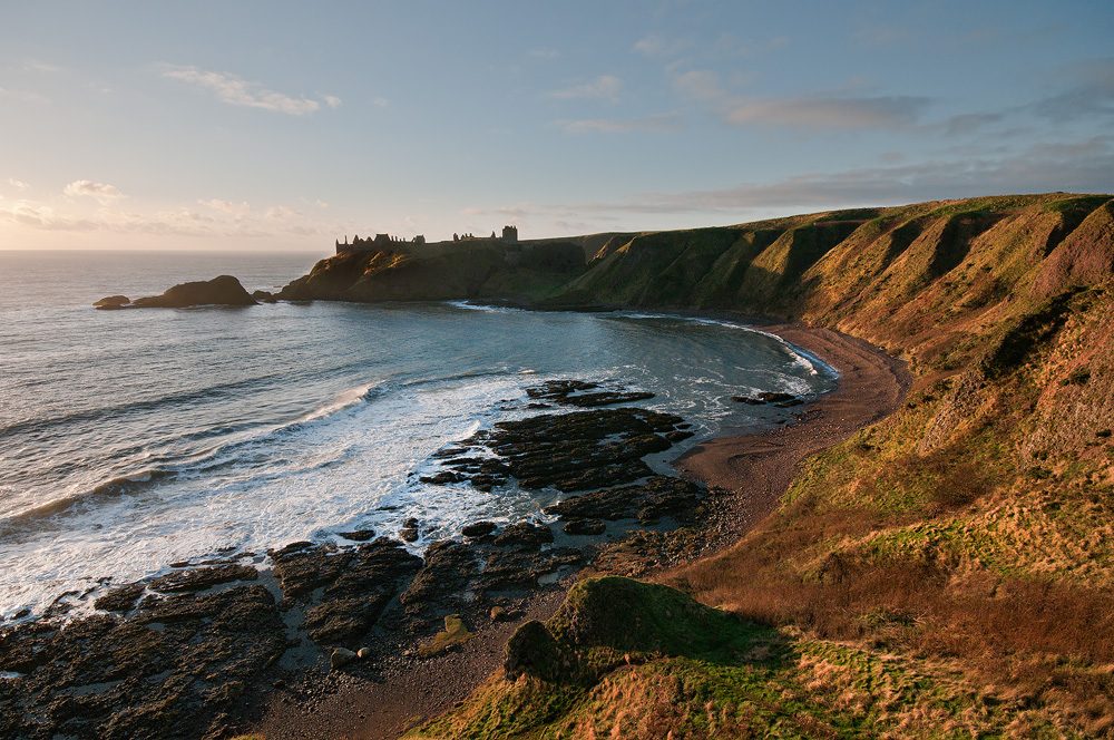 Dunnottar Castle seen in low light from the coast path north of the castle, the free viewpoint